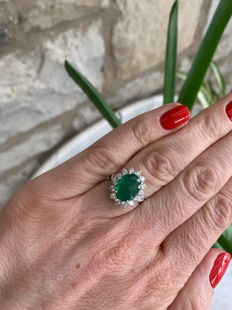 Oval shaped Emerald and Diamond cluster ring set in 18ct white gold